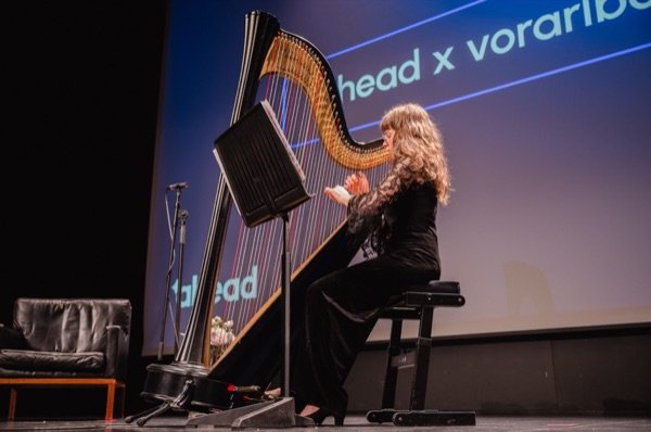 Eine Harfenistin spielt auf der Bühne eines früheren ahead x Abends